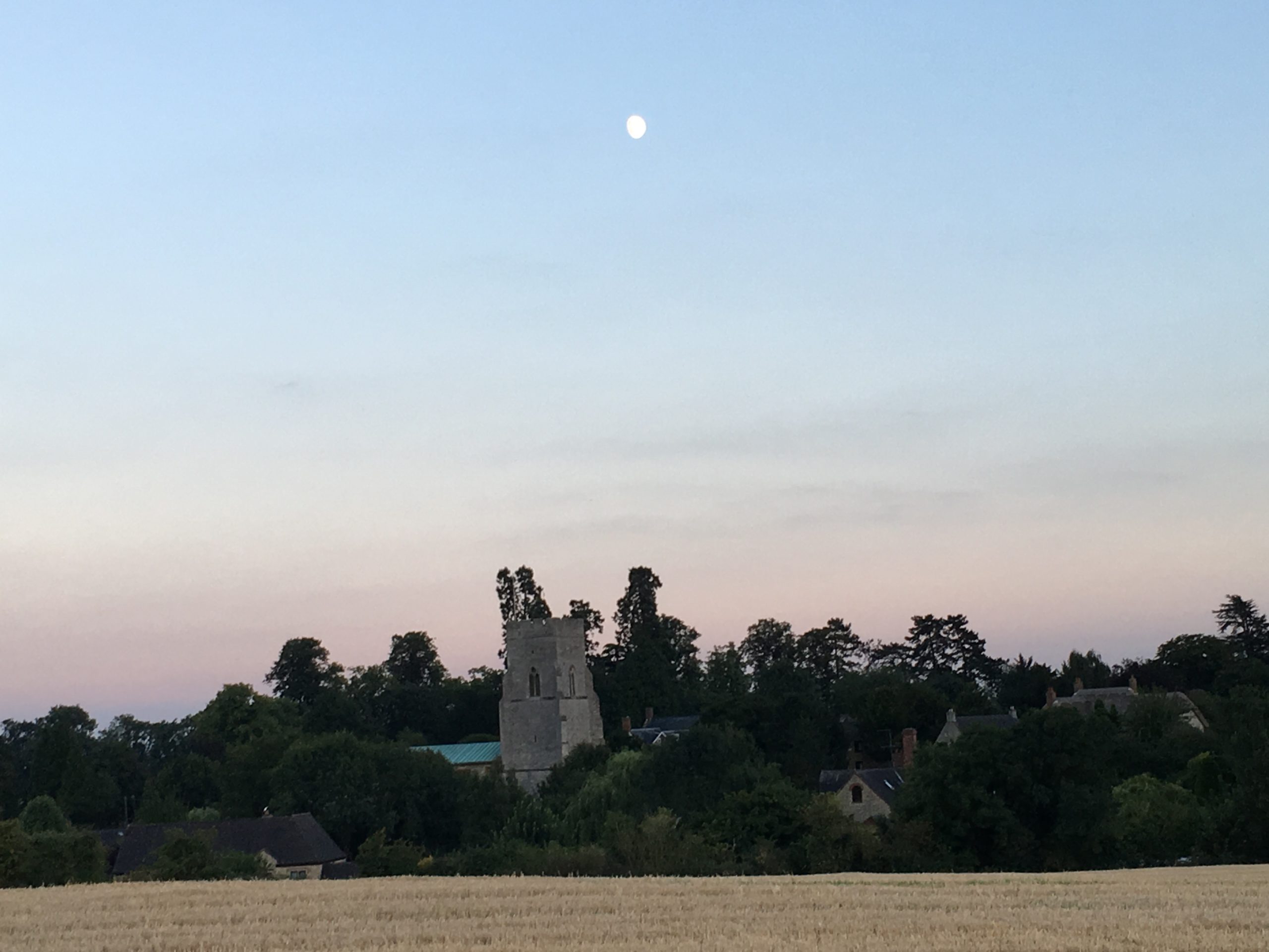 Dusk and the moon over a village